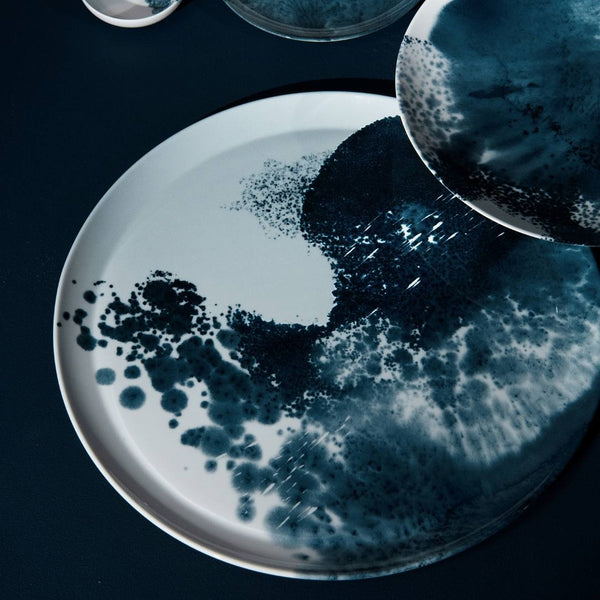 Large round serving platter Abysses collection by Raynaud Limoges porcelain on a dark surface