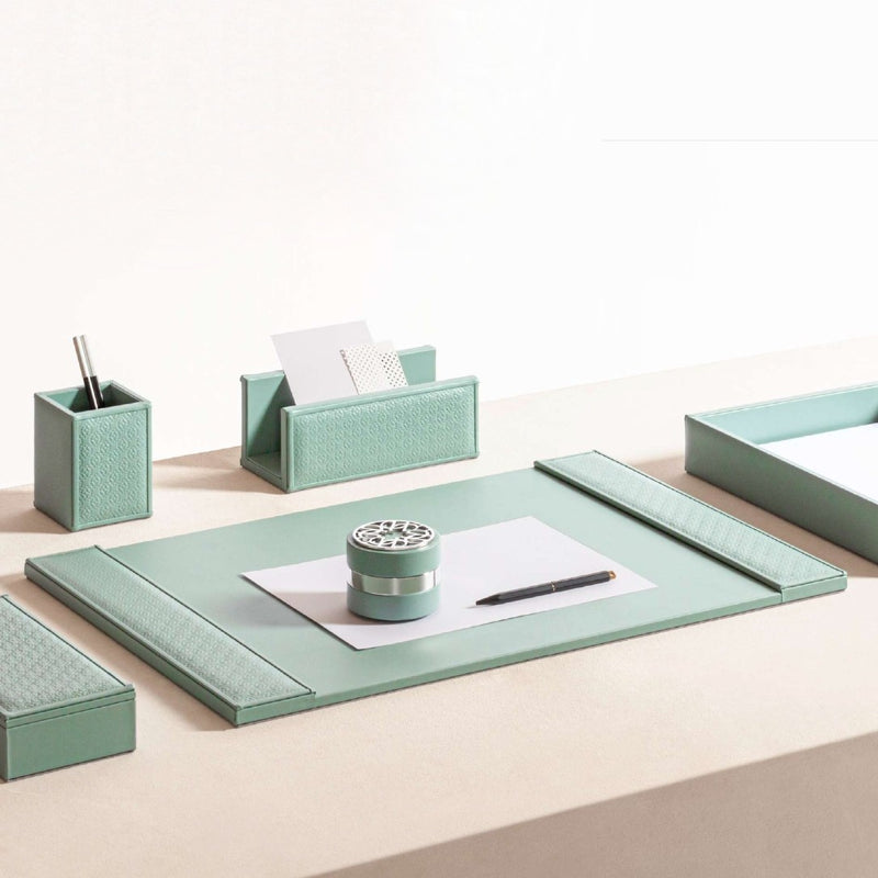Mint green desk set with organizer, pen holder, and paper on a light beige surface.