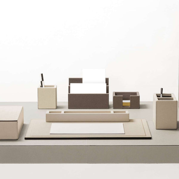 Beige office desk set with various items on a white background