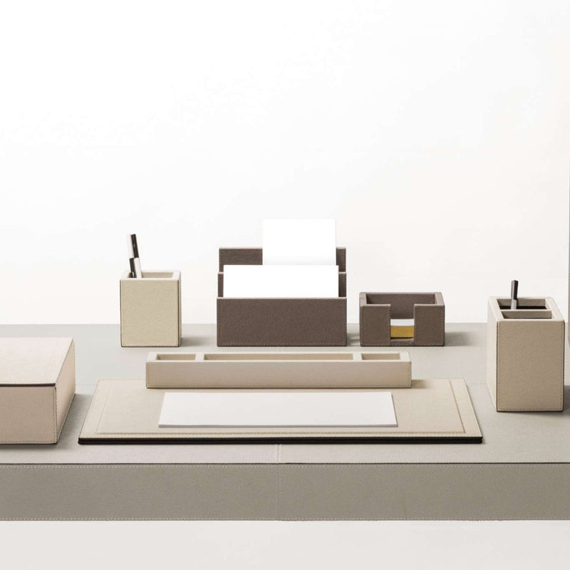 Beige office desk set with various items on a white background