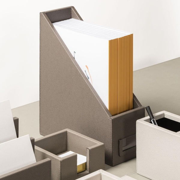 Gray desk organizer with files and a pen on a white background