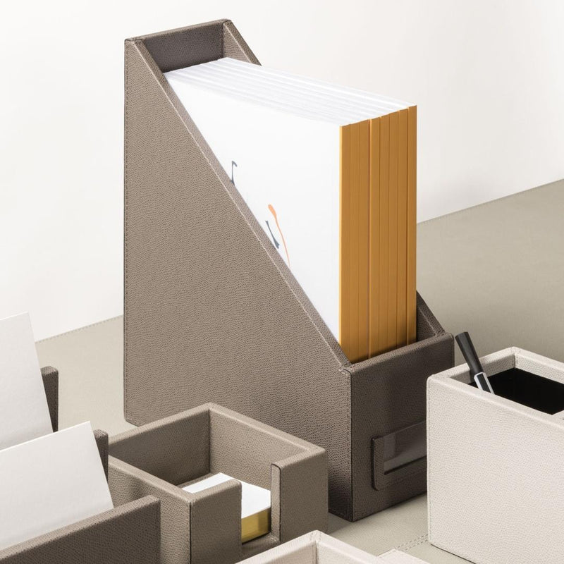 Gray desk organizer with files and a pen on a white background