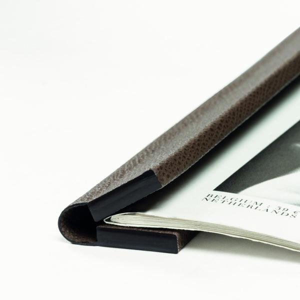 Close-up Giobagnara leather magnetic sheets holder gripping a magazine with strong inner magnetic clasp
