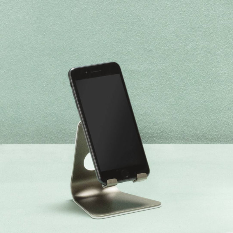 Phone on a stand against a light green background