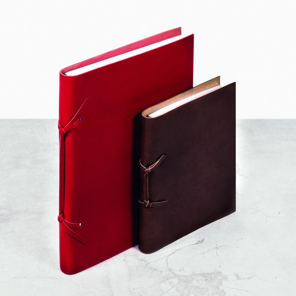 Red and brown Saddle leather Legacci notebooks by Giobagnara x Rabitti with unique binding and ivory pages
