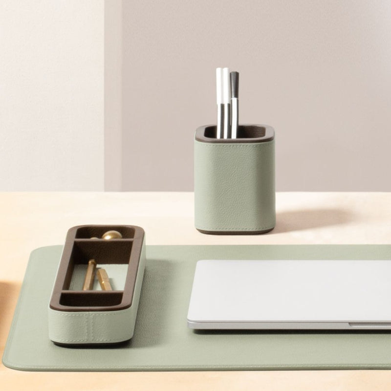 Desk organizer with pen holder, tray, and laptop on a light surface.