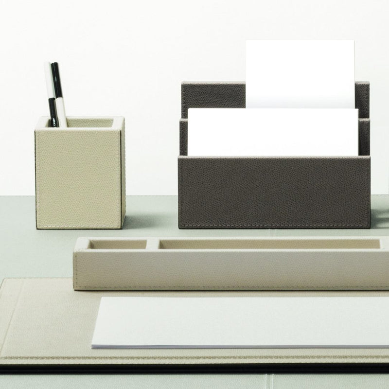 Desk organizer with pen holder, letter tray, and paper on a white background