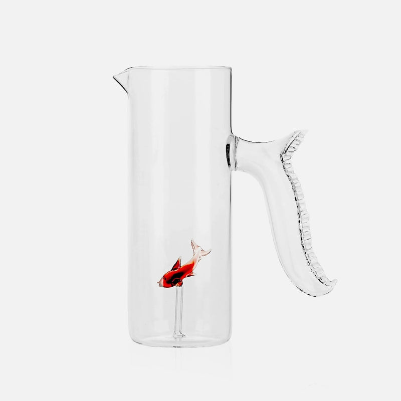 Clear glass pitcher with a fish design on a white background