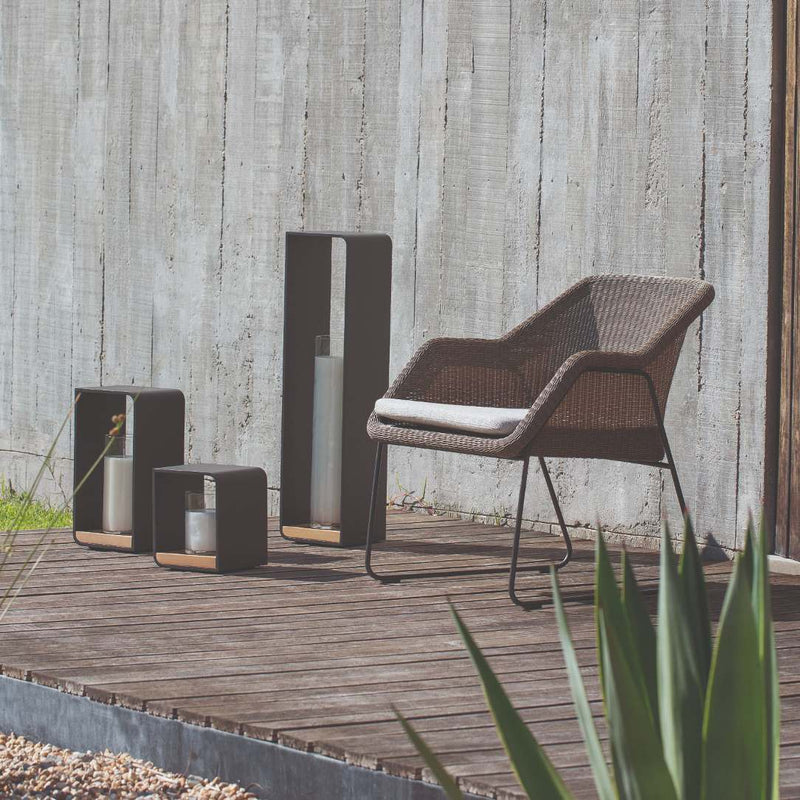 styled corner with chair and Lumo rechargeable outdoor lantern in Lava, with Iroko wood base and aluminium frame by Manutti