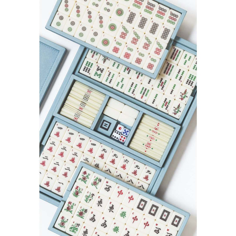 Mahjong set with tiles and components in a blue leather box on a white background