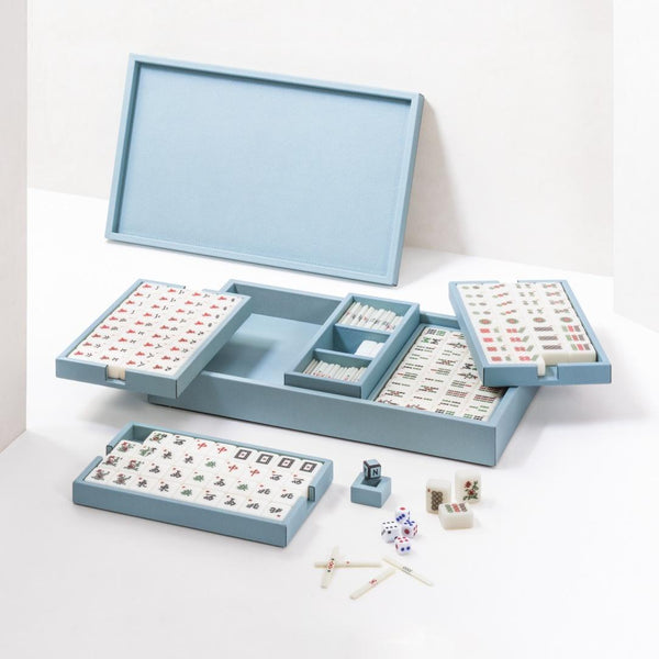 Blue mahjong set with tiles and accessories on a white background