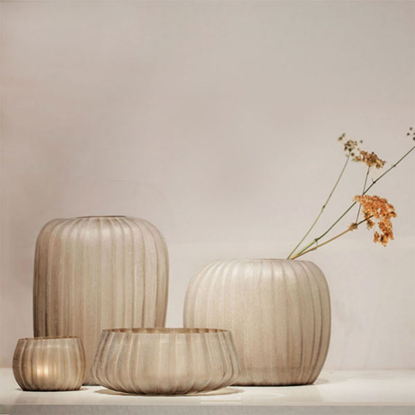 Set of glass vases with ribbed texture on a neutral background