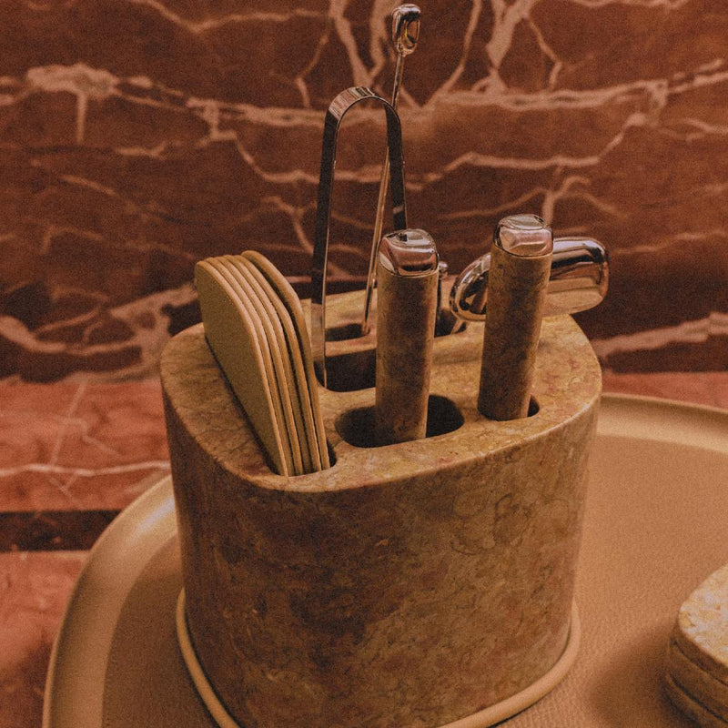 Styled tray with Maris bar accessories set by Kelly Wearstler x Giobagnara with marble base, stainless steel tools, and leather coasters