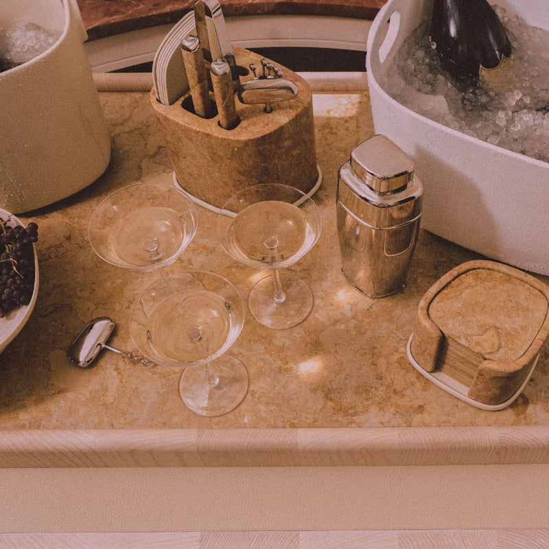 Styled bar counter with Maris bar accessories set by Kelly Wearstler x Giobagnara with marble base, stainless steel tools, and leather coasters