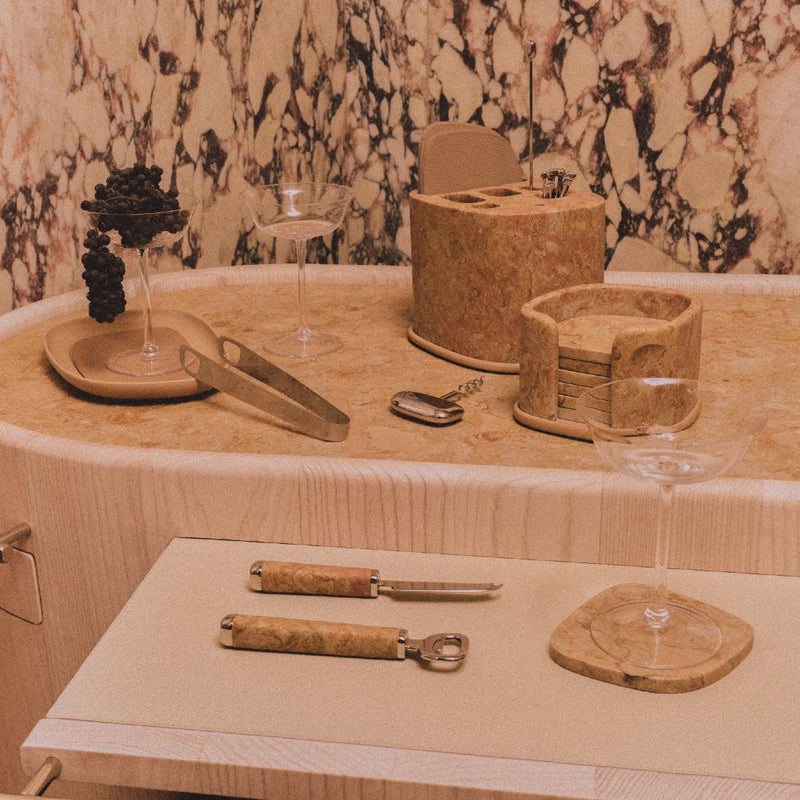 Styled bar featuring Maris Bottle Opener in stainless steel and marble Royal Yellow by Kelly Wearstler x Giobagnara