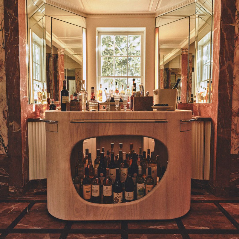 Styled bar featuring Styled bar counter with Maris champagne bucket for 3 in cast aluminium by Kelly Wearstler x Giobagnara, cappuccino finish
