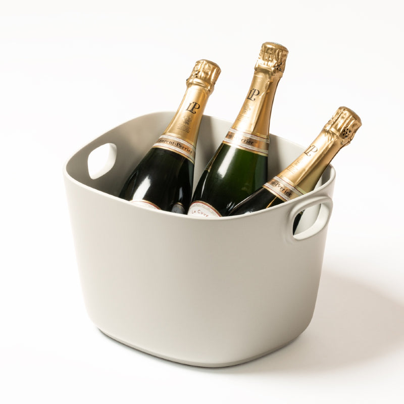A beige cast aluminium champagne bucket with handles, designed by Kelly Wearstler x Giobagnara.
