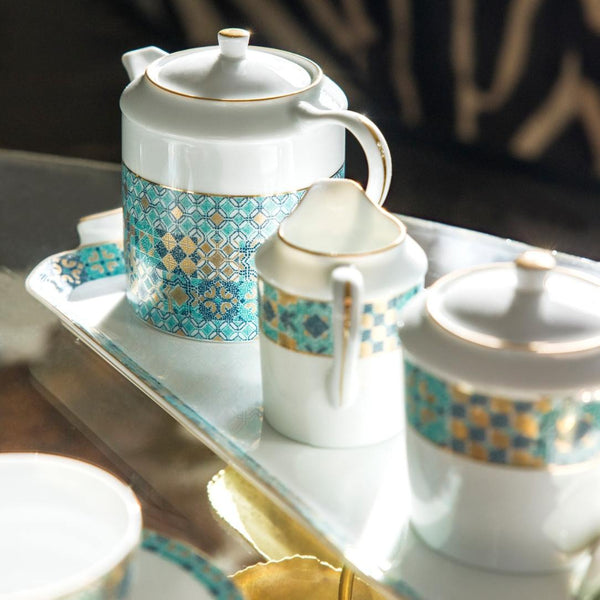Tea set with decorative patterns on a reflective surface