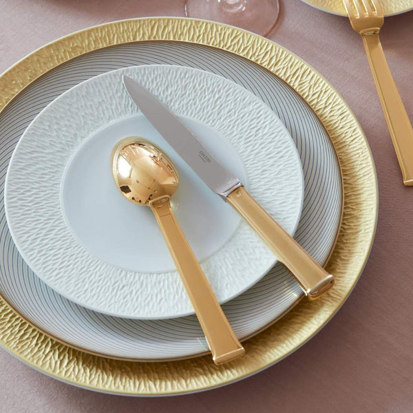 Dining setting with gold cutlery and Minéral White dessert plate by Raynaud