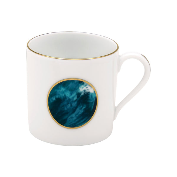 White mug with a gold rim and a blue circular design on a white background