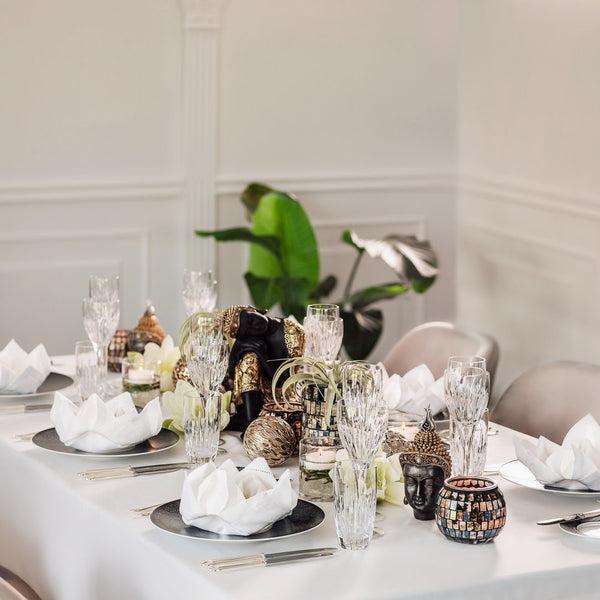 Elegant table setting with decorative items and plants in the background