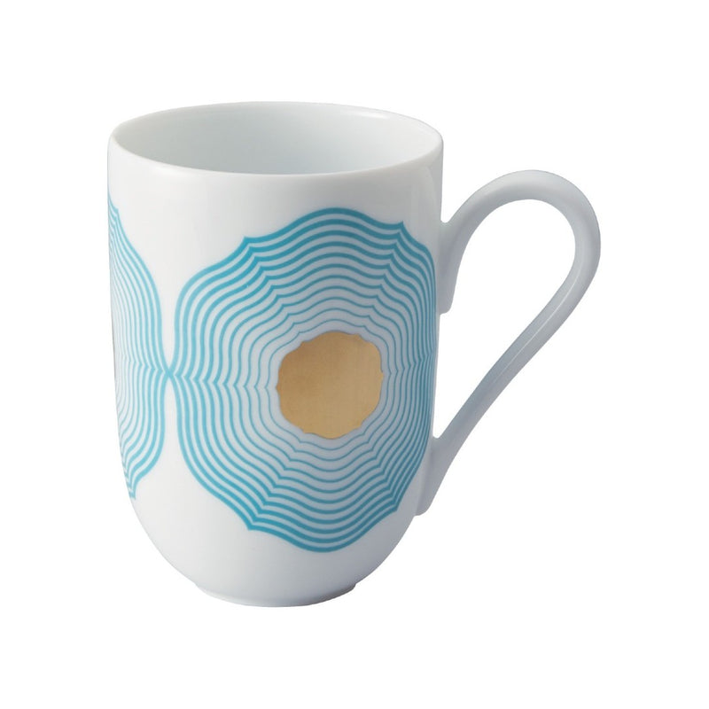 White mug with blue and gold geometric design on a white background