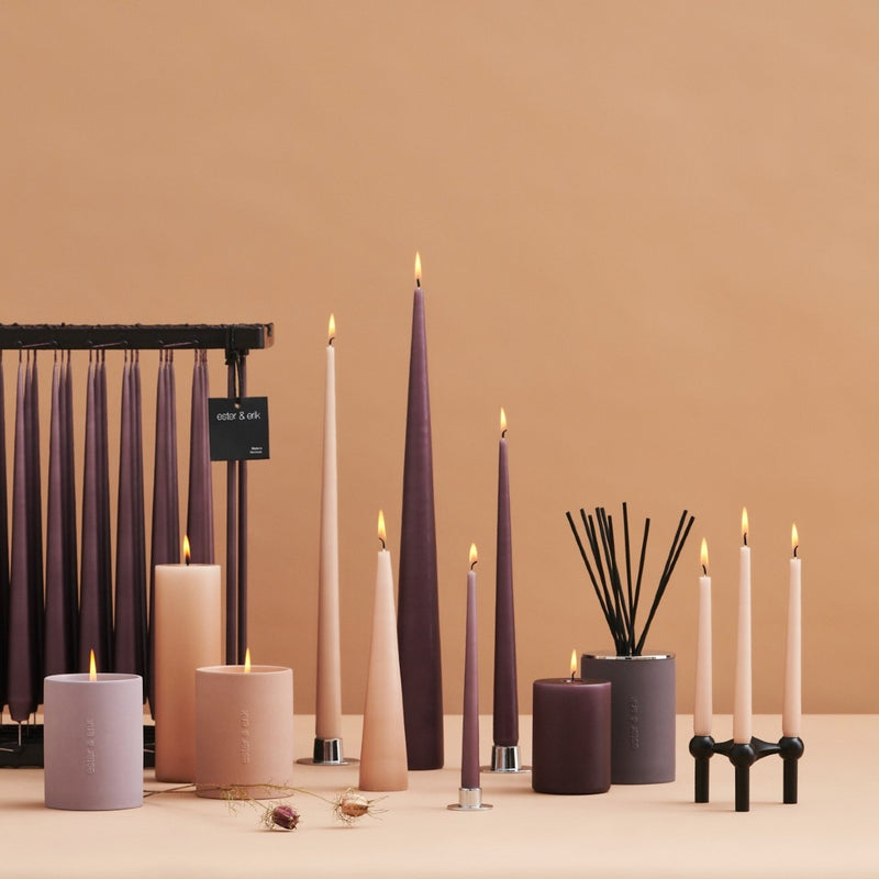 Assorted candles and candle holders on a beige background