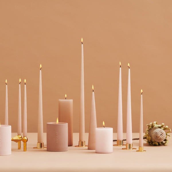 Arrangement of candles on a beige surface with a brown background