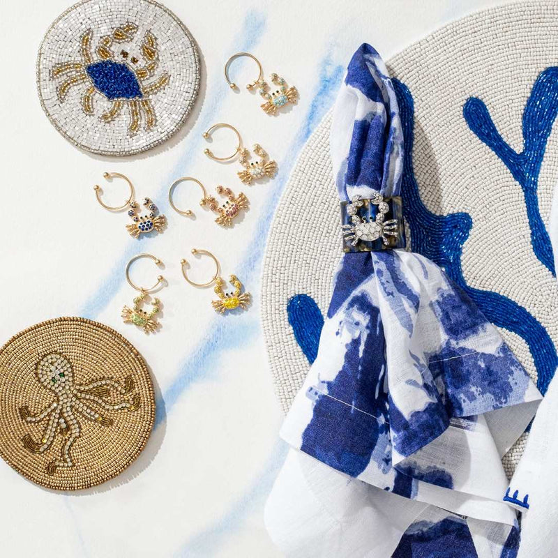 Decorative items including coasters, earrings, and a napkin with a blue and white pattern on a light background.