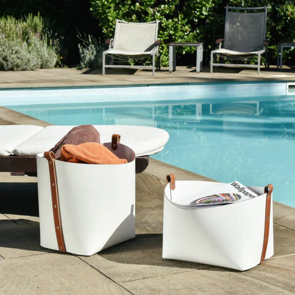 White outdoor storage Ovo baskets with brown accents by a poolside.
