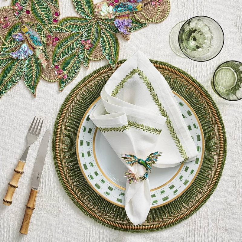 table placemat with green beads with a white plate and runner in green and multi on a white tablecloth