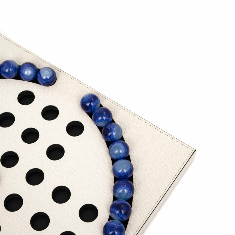 Close-up of Luxury Peg Solitaire game in cream grained leather with 33 blue eco-shell pawns by Pinetti