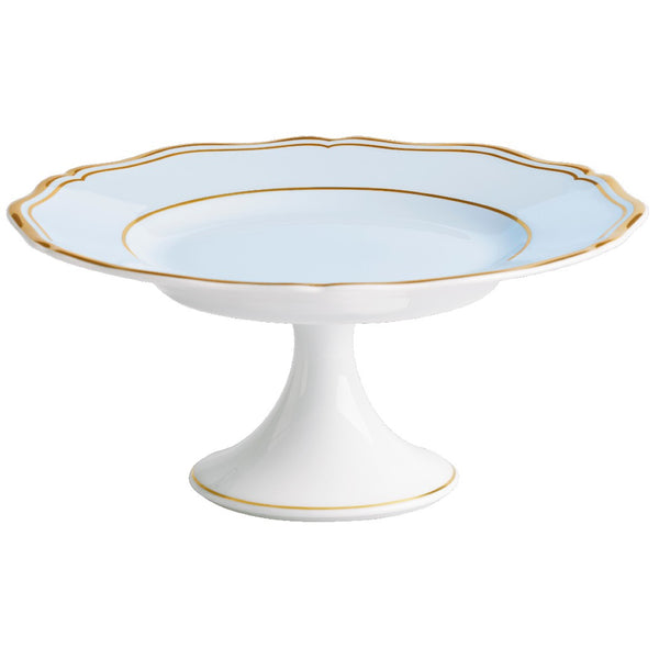 A round, blue-grey porcelain cake stand with gold trim and a scalloped edge, featuring a white base and gold handles.