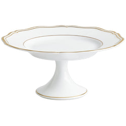A white porcelain cake stand with gold accents and a scalloped edge.