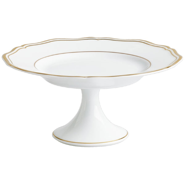 A white porcelain cake stand with gold accents and a scalloped edge.
