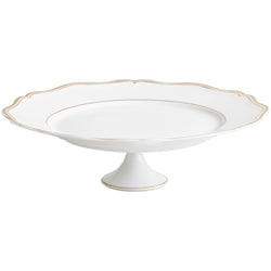 A white porcelain cake stand with gold accents and a scalloped edge.
