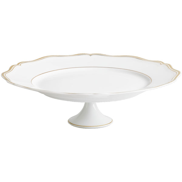 A white porcelain cake stand with gold accents and a scalloped edge.