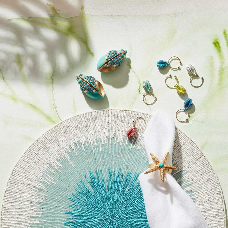 Collection of colorful place card holders on a textured surface with a starfish accent.