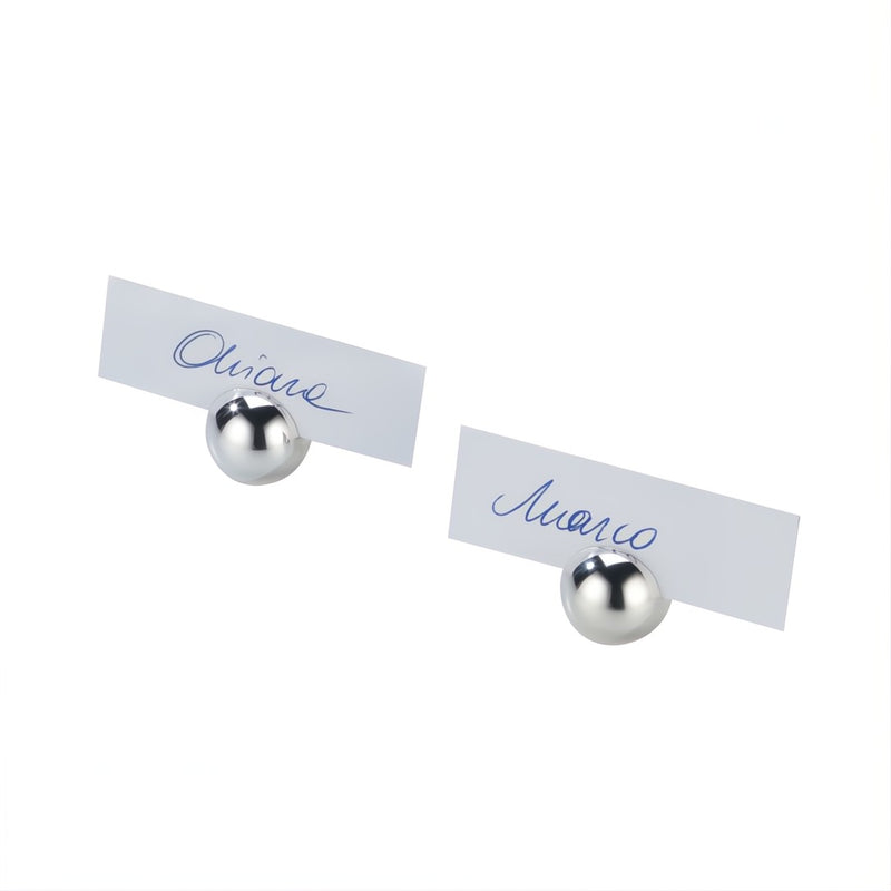 Two silver ball-shaped place card holders with white cards labeled 'Olivier' and 'Manuel' on a white background.