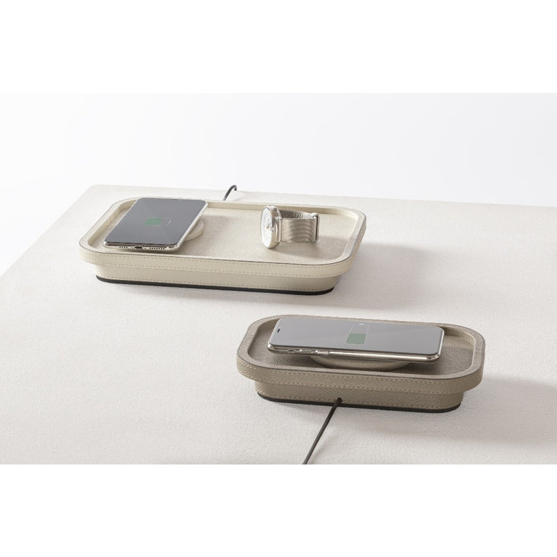 Two wireless charging pads on a white surface with smartphones on top.