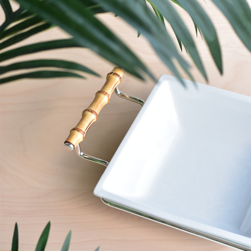 Close-up of porcelain square salad bowl from the Linea collection by Schiavon on a wooden surface with green leaves in the background