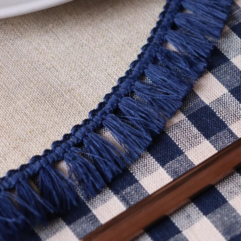 Close-up of a blue fringed border on a checkered fabric background