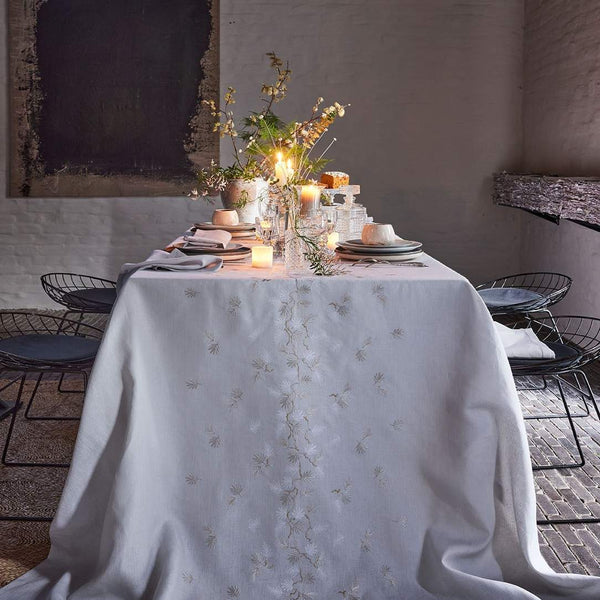 Elegant table setting with a floral centerpiece in a rustic indoor setting.