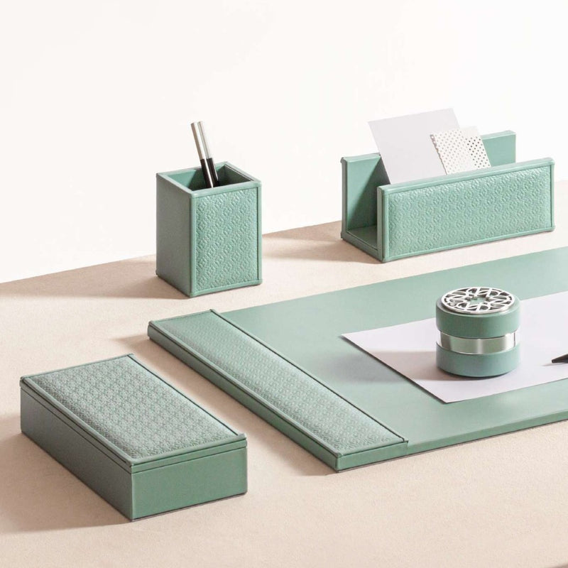 Mint green desk set with various items on a light beige surface