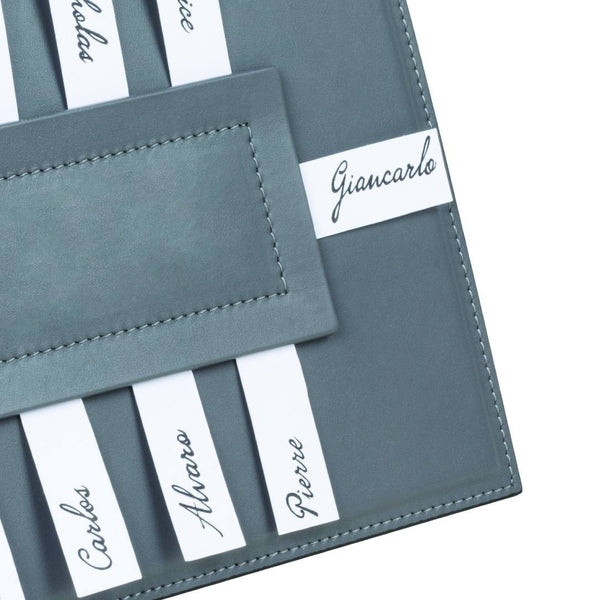 Close-up Rectangular Leather Seating Chart Aspen by Giobagnara in grey leather, displaying name cards for elegant table seating arrangements.