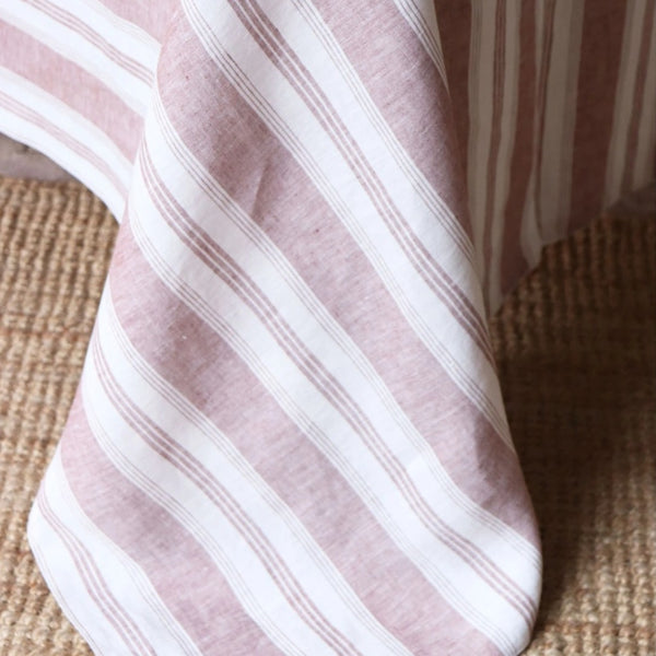 Close-up of a pink and white striped fabric on a textured surface