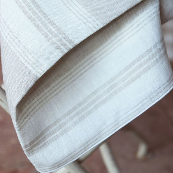Close-up of a white fabric with subtle stripes on a blurred background