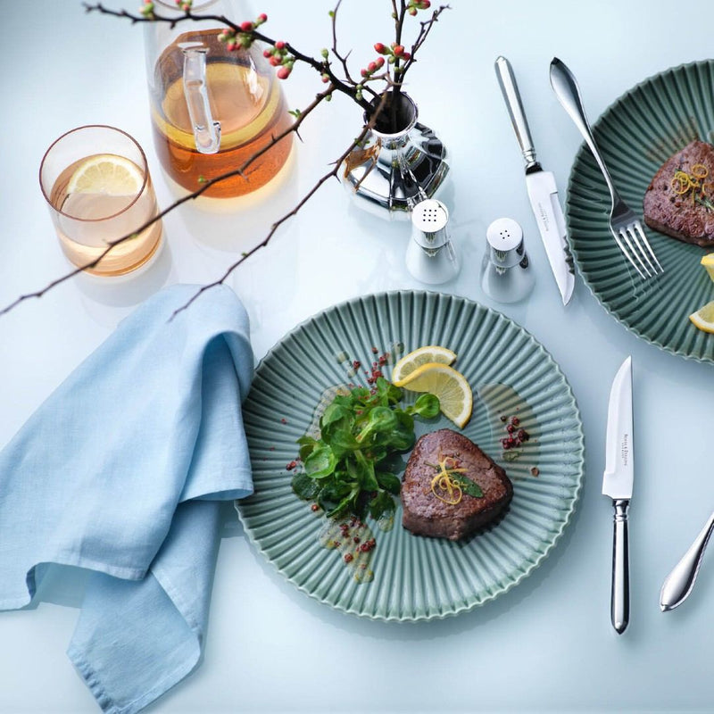Dinner setting with plates, cutlery, and Salt and Pepper Set Leon Silver-Plated by Robbe & Berking on a light blue tablecloth.