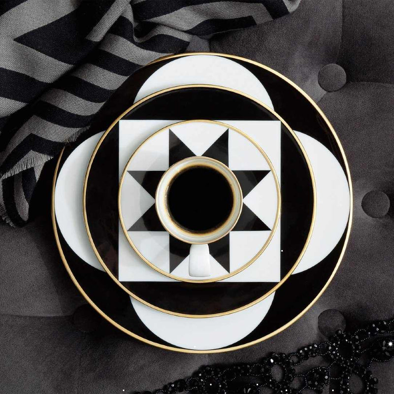 Designer porcelain saucer with rim from ca d oro series sieger furstenberg with a cup on a dark background