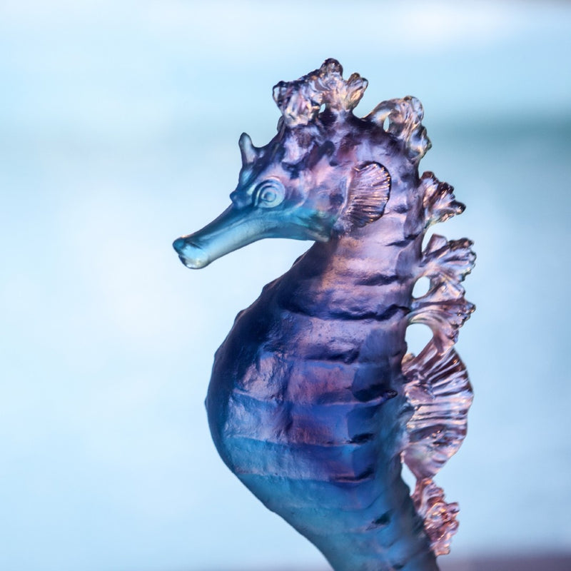 Glass seahorse sculpture on a light blue background